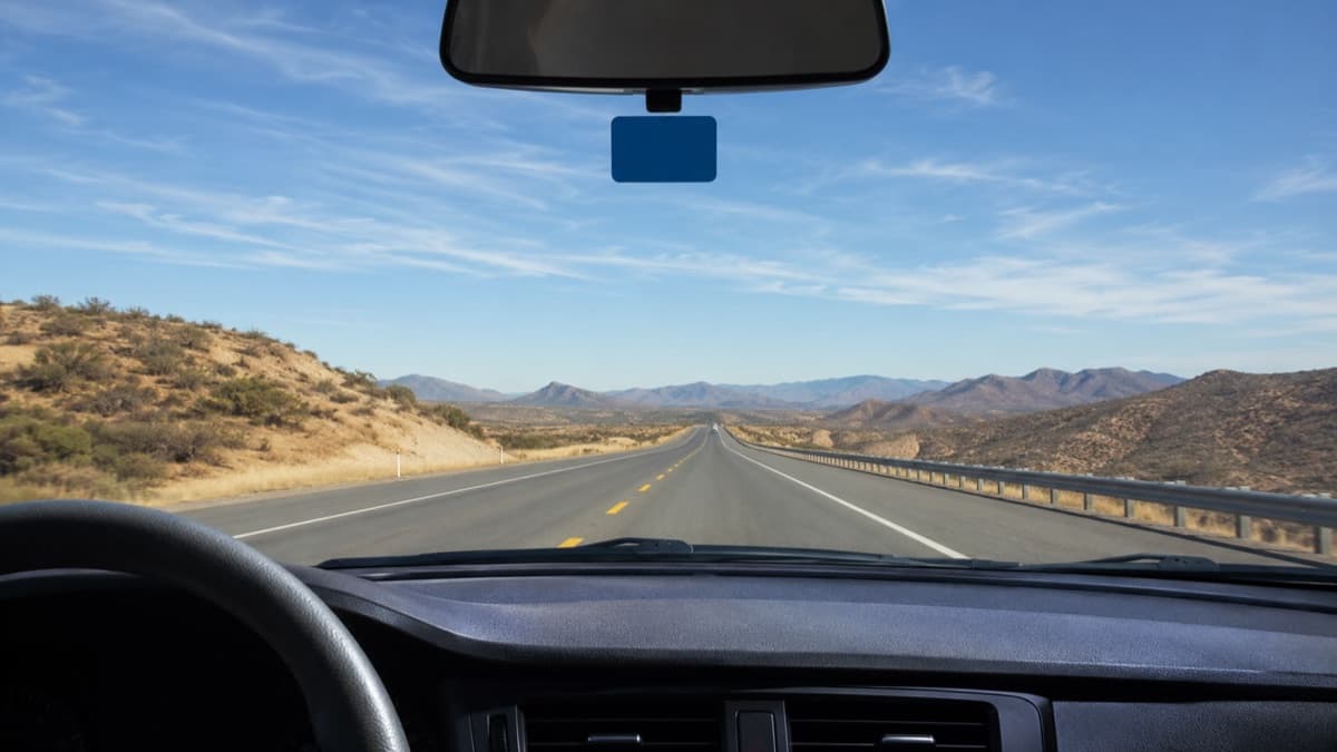 Dispositivo TAG IAVE azul instalado tras el parabrisas de un coche en una autopista mexicana