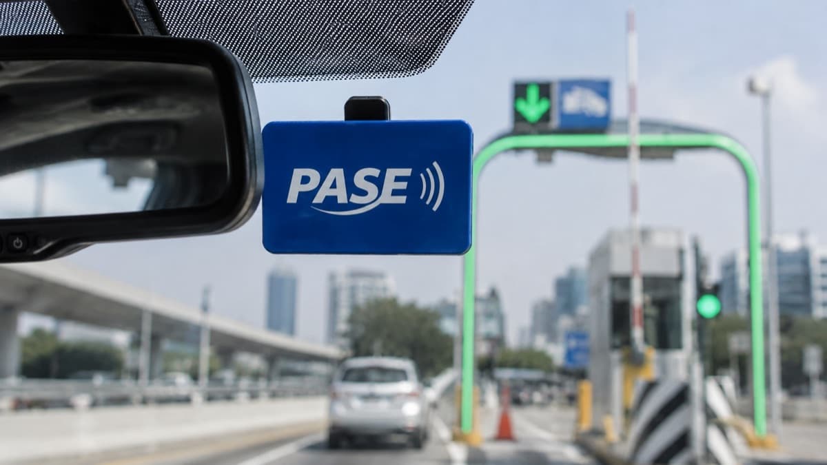 Dispositivo TAG PASE en parabrisas con cabina de cobro electrónico al fondo